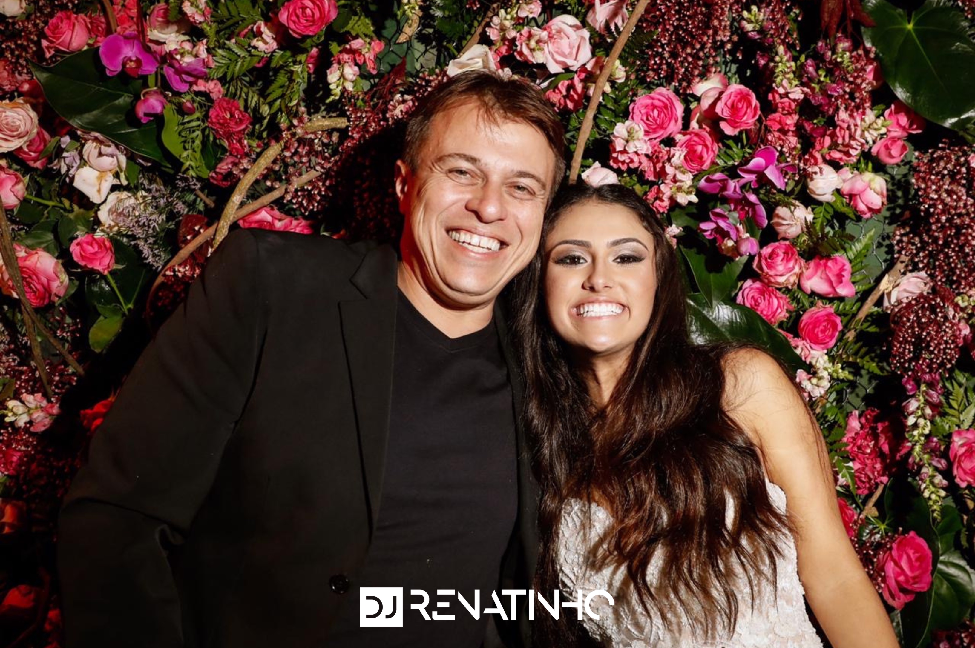 DJ Renatinho com a aniversariante em parede de flores